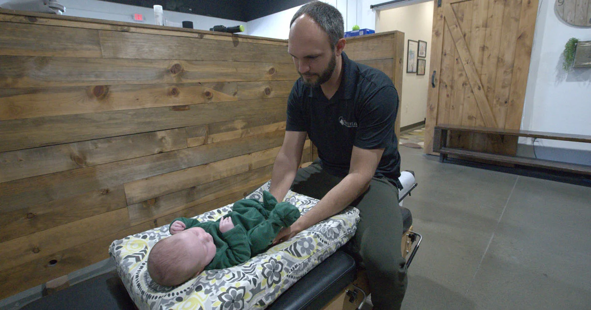 Chiropractor caring for an infant during a gentle pediatric chiropractic visit at Trailhead Family Chiropractic in Murrieta, CA