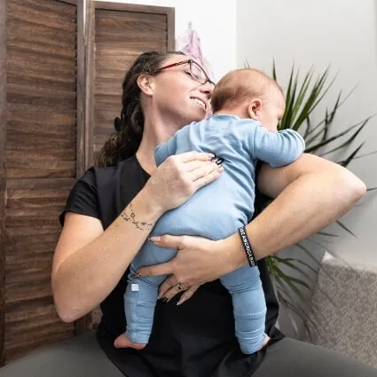 Chiropractor holding an infant during a gentle pediatric chiropractic visit at Trailhead Family Chiropractic in Murrieta, CA
