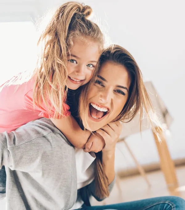 Mother and daughter smiling together, representing family wellness and healthy childhood support at Trailhead Family Chiropractic