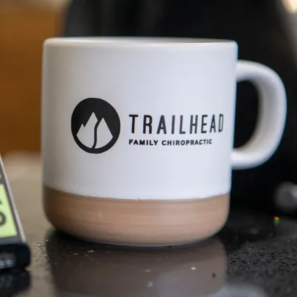 Branded Trailhead Family Chiropractic mug on the front desk in Murrieta, CA