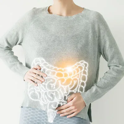 Woman holding her stomach with a digestive system illustration, representing gut health and holistic wellness support through chiropractic care