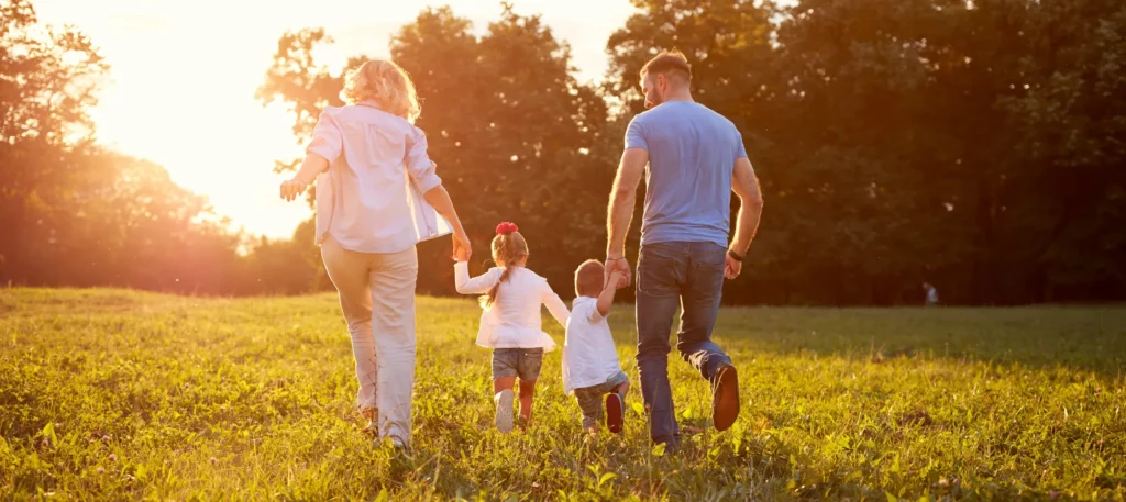 Family walking together outdoors at sunset, representing healthy movement, connection, and family wellness supported by chiropractic care