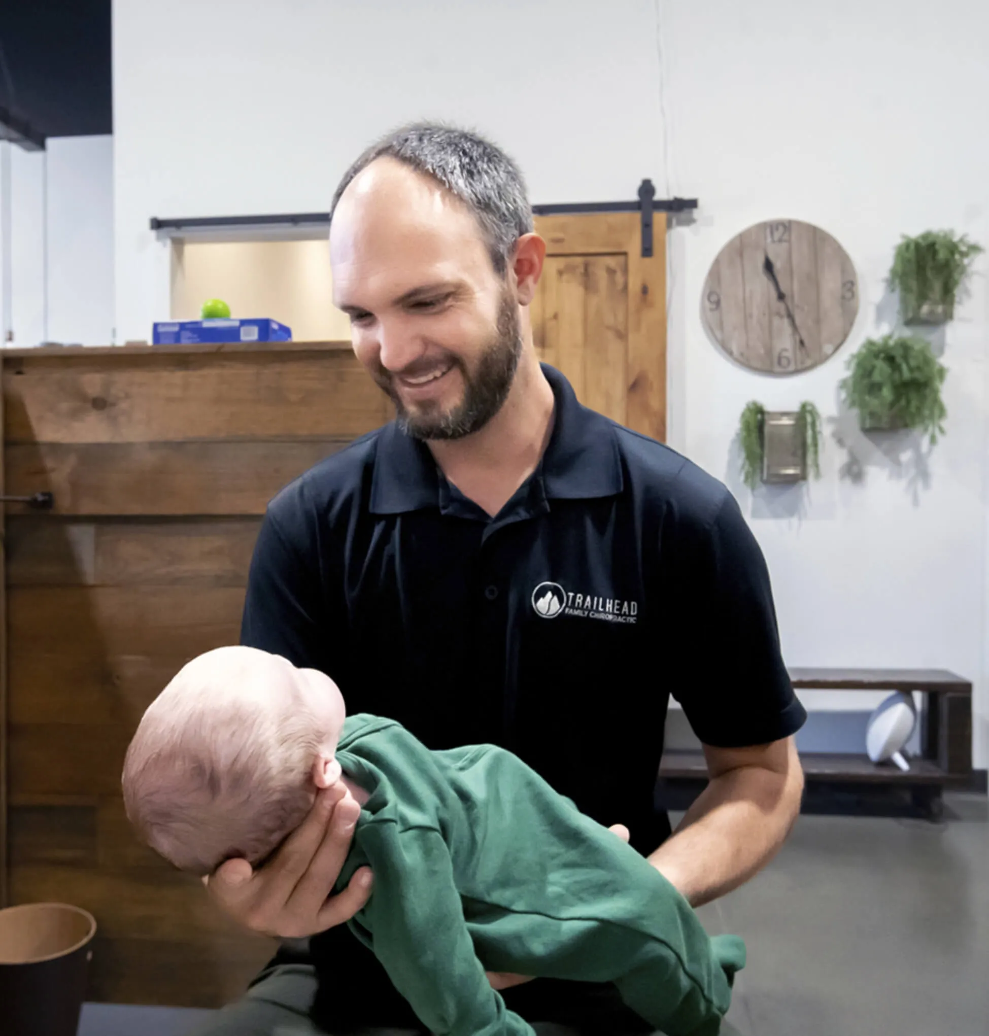 Chiropractor holding an infant during a pediatric chiropractic visit at Trailhead Family Chiropractic in Murrieta, CA