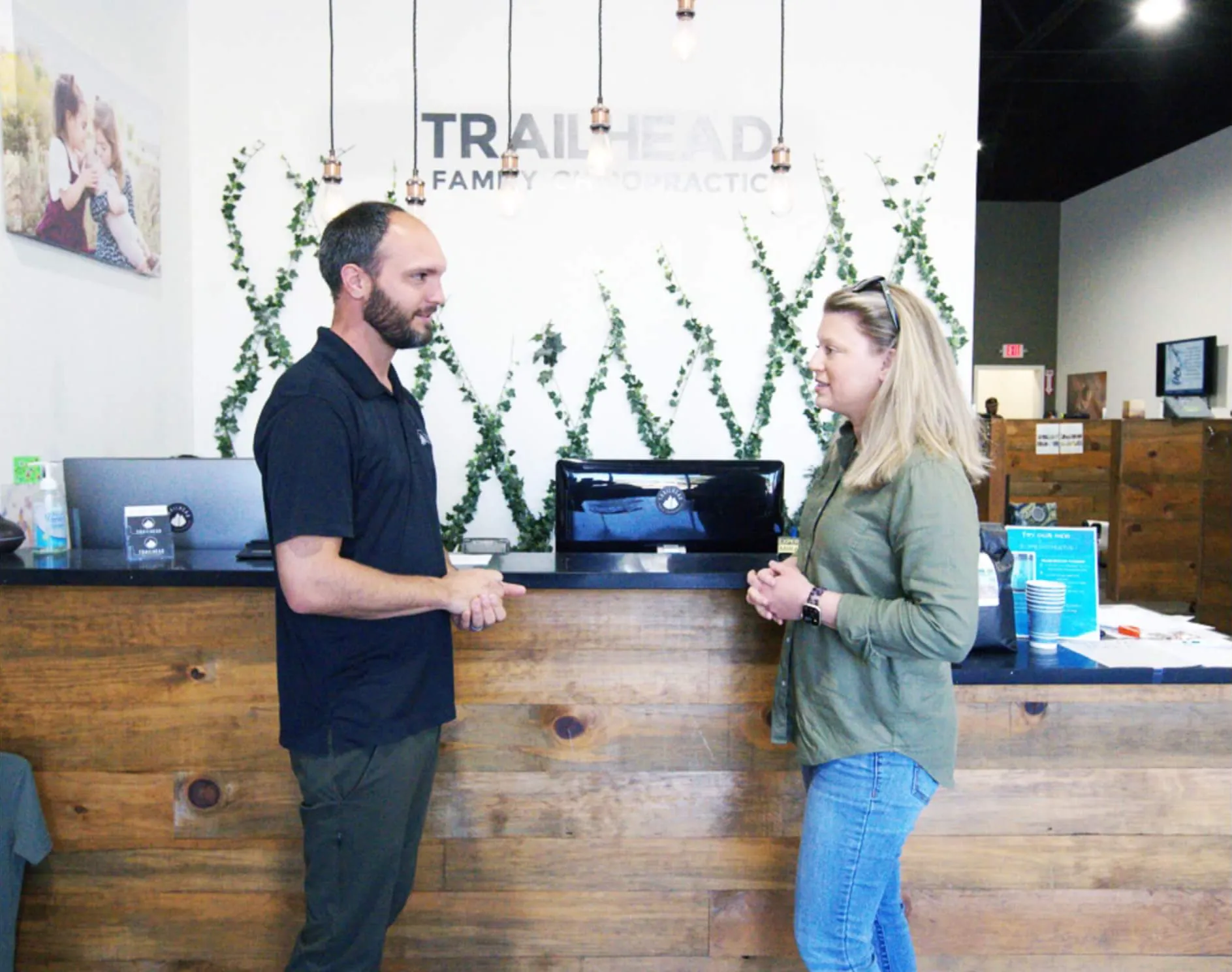 Chiropractor speaking with a patient at the front desk of Trailhead Family Chiropractic in Murrieta, CA