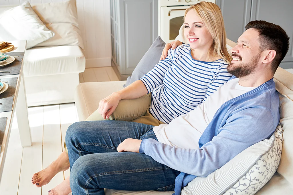 Couple sitting together and relaxing on a couch in a bright home